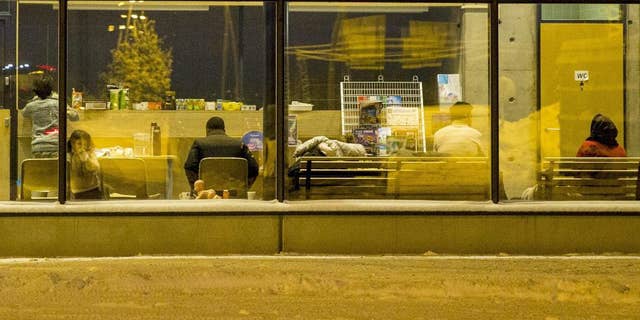 FIL:E - This is a January 20, 2016 file photo of unidentified migrants as they wait onward transportation at the border crossing station in Salla, Northern Finland, after crossing the border from Russia to Finland. Finnish border officials have broken up a ring of international human traffickers who allegedly smuggled migrants into the country from Russia across the European Union’s two northernmost border points in Arctic Finland, a Finnish Border Guard investigator said Monday May 9, 2016. (Kaisa Siren/Lehtikuva, File via AP) FINLAND OUT