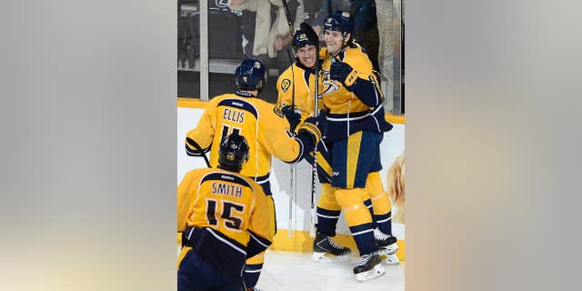 Nashville Predators center Filip Forsberg (9) celebrates with center Derek Roy (21), defenseman Ryan Ellis (4) and center Craig Smith (15) after Forsberg scored against the Calgary Flames in the first period of an NHL hockey game Tuesday, Oct. 14, 2014, in Nashville, Tenn. (AP Photo/Mark Zaleski)