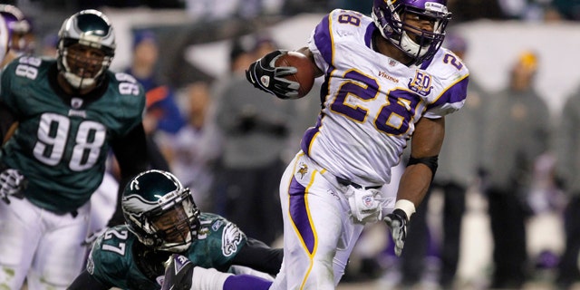 Minnesota Vikings running back Adrian Peterson (28) breaks a tackle from the Philadelphia Eagles safety Quintin Mikell (27) during the third quarter of their NFL football game in Philadelphia, Pennsylvania, December 28, 2010. REUTERS/Tim Shaffer (UNITED STATES - Tags: SPORT FOOTBALL)
