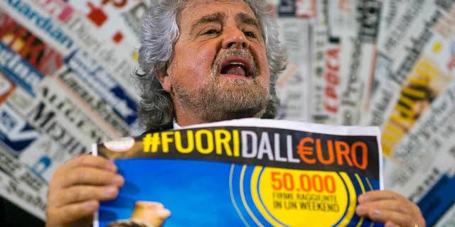 FILE - In this Dec. 18, 2014 file photo, 5-Star Movement leader Beppe Grillo shows a poster in Italian reading "Out of the euro, 50,000 signatures already collected in a weekend", as he speaks during a press conference at the Foreign Press Club in Rome. Italy's populist 5-Star Movement on Monday, Jan. 9, 2017 voted to join the liberal ALDE group in the European Parliament in an about-face power play that has sent shockwaves through the European Union legislature. (AP Photo/Domenico Stinellis, File)