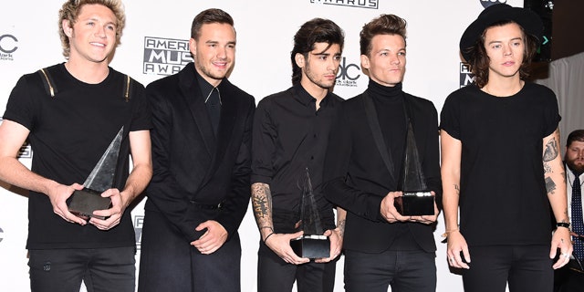 November 23, 2014: Niall Horan, Liam Payne, Zayn Malik, Louis Tomlinson and Harry Styles, of One Direction, pose in the press room with the awards for artist of the year, favorite pop/rock album for 'Midnight Memories' and pop/rock band, duo or group at the 42nd annual American Music Awards at Nokia Theatre L.A. Live in Los Angeles. (Photo by Jordan Strauss/Invision/AP)