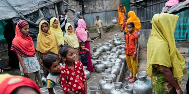 FILE - In this Dec. 3, 2016, file photo, Rohingya women and children wait in a queue to collect water at the Leda camp, an unregistered camp for Rohingya in Teknaf, near Cox's Bazar, a southern coastal district about, 296 kilometers (183 miles) south of Dhaka, Bangladesh. Abuses appear to be “normal and allowed” in Myanmar’s security crackdown in response to an armed uprising among its Rohingya Muslims, a senior U.S. official said in an interview, casting a pall over one of President Barack Obama’s legacy foreign policy achievements. (AP Photo, File)