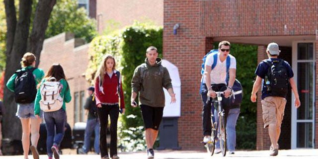 Students are pictured walking through a college campus.
