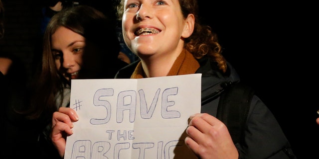 Greenpeace International activist Ana Paula Alminhana Maciel of Brazil holds a poster as she is released from jail on bail in St. Petersburg, Russia, Wednesday, Nov. 20, 2013. Russian courts granted bail Wednesday to the American captain and four others arrested on a Greenpeace ship over a protest against oil drilling in the Arctic. They are among 30 people detained in the case. (AP Photo/Dmitry Lovetsky)
