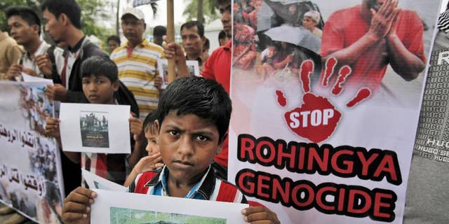 Ethnic Rohingya migrants hold banners during a rally in Medan, North Sumatra, Indonesia, Tuesday, May 12, 2015. Hundreds of migrants abandoned at sea by smugglers in Southeast Asia have reached land and relative safety in the past two days. But an estimated 6,000 Bangladeshis and Rohingya Muslims from Myanmar remain trapped in crowded, wooden boats, migrant officials and activists said. With food and clean water running low, some could be in grave danger. (AP Photo/Binsar Bakkara)