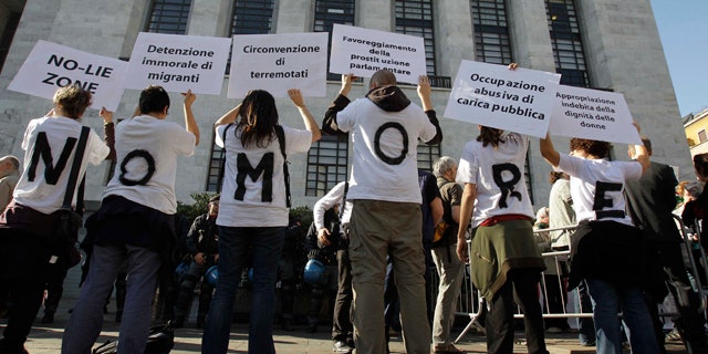 April 6: People wear t-shirts composing the sentence "No more" as they hold up placards during a protest outside the Milan court in Italy.
