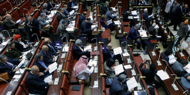 Members of Egypt's panel tasked with amending Egypt's Islamist-drafted constitution, read drafts of the constitution before they begin voting on a series of amendments, in the Shoura Council, Cairo, Egypt, Saturday, Nov. 30, 2013. The 50-member committee will hand in the draft constitution to interim Egyptian President Adly Mansour, who has a month to call for a public vote on it. (AP Photo/Amr Nabil)