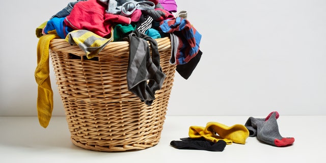 Overflowing laundry basket. Household chore concept on white background
