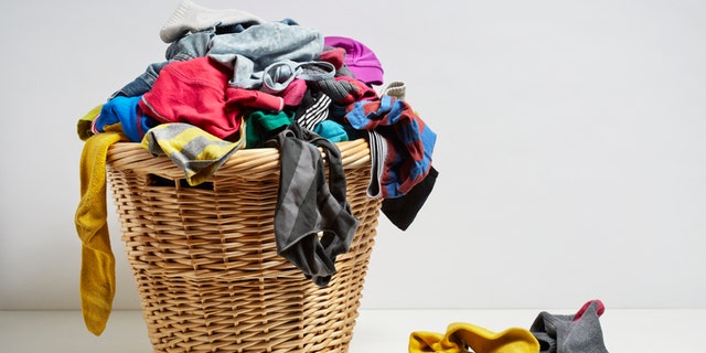 Overflowing laundry basket. Household chore concept on white background