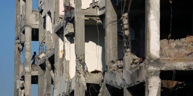 A Palestinian man inspects the damage of his flat in the destroyed Nada Towers residential neighborhood in the town of Beit Lahiya, northern Gaza Strip, Monday, Aug. 11, 2014. A new temporary truce took hold, Monday, in the monthlong war pitting the Israeli military against rocket-firing Hamas militants as negotiators from Israel and the Hamas militant group resumed indirect talks in Egypt on Monday. (AP Photo/Khalil Hamra)