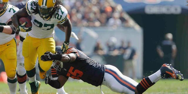Green Bay Packers running back Eddie Lacy (27) tries to avoid a tackle by Chicago Bears linebacker Lance Briggs (55) in the first half of an NFL football game Sunday, Sept. 28, 2014, in Chicago. (AP Photo/Nam Y. Huh)