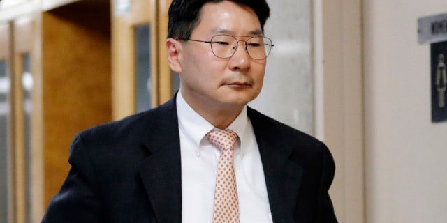 April 27: Dr. Robert Rho walks toward the courtroom for his trial at Queens County Criminal Court in New York.