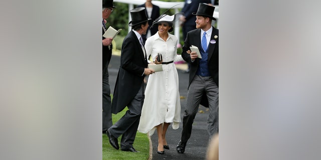 The Duchess of Sussex paired her collared shirt dress with a thin black belt, black clutch and black pumps.