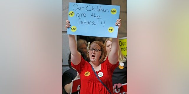 FILE -- March 9, 2015: Kristi Jacobsen, a second grade teacher from Ogden, shows her support while gathered with others during the stand up for public education rally at the Utah State Capitol Monday, , in Salt Lake City.