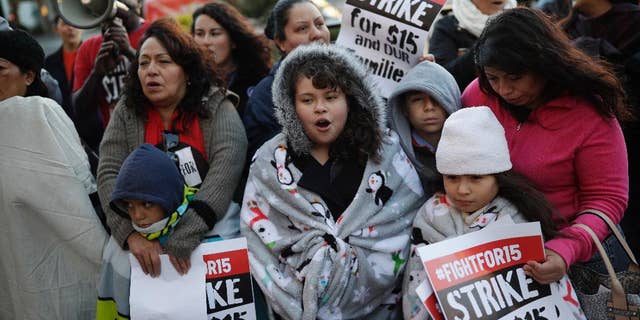 FILE – In this Nov. 29, 2016, file photo, people protest as part of the National Day of Action to Fight for $15 near a McDonald's restaurant along the Las Vegas Strip in Las Vegas. A cluster of Black Lives Matter groups and the organization leading the push for a $15-an-hour wage are joining forces to combine the struggle for racial justice with the fight for economic equality, just as the Rev. Martin Luther King Jr. tried to do in the last year of his life. They are launching their first national joint action on April 4, 2017, the 49th anniversary of King’s assassination, with “Fight Racism, Raise Pay” protests in two dozen cities, including Atlanta; Chicago; Boston; Denver; and Las Vegas. (AP Photo/John Locher, File)