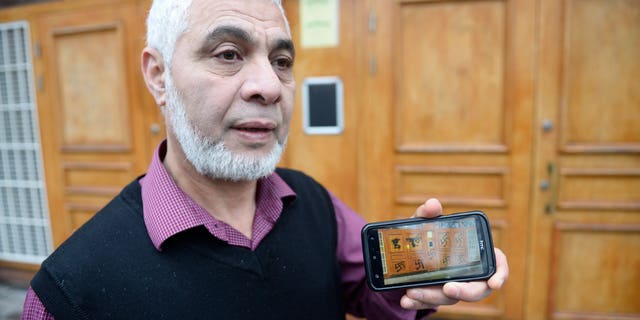 Imam Mamut Kalfi shows on his mobile phone the pictures he has taken of the vandalism that took place on the doors to the central Stockholm mosque Thursday, Jan. 2, 2014. Swedish police have opened a hate crime investigation after the swastikas were spray-painted on the entrance of the mosque in Stockholm. Omar Mustafa, the head of Sweden’s Islamic federation, said employees discovered the vandalism as they arrived to open the mosque Thursday morning. Mustafa said the mosque is targeted by hate mail or vandalism about twice a month, but this is the first time someone’s defaced the entrance with swastikas since the mosque was built in 2000. (AP Photo/TT, Leif R Jansson) SWEDEN OUT