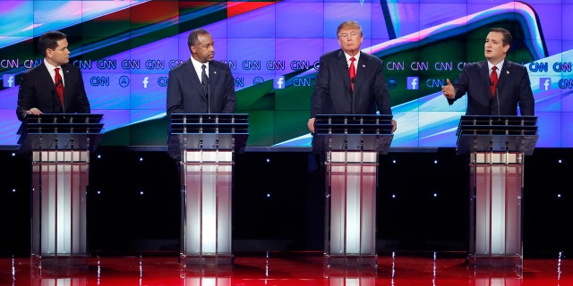 Ted Cruz, right, speaks during an exchange with Marco Rubio, left, as Ben Carson, second from left, and Donald Trump look on during the CNN Republican presidential debate at the Venetian Hotel & Casino on Tuesday, Dec. 15, 2015, in Las Vegas. (AP Photo/John Locher)