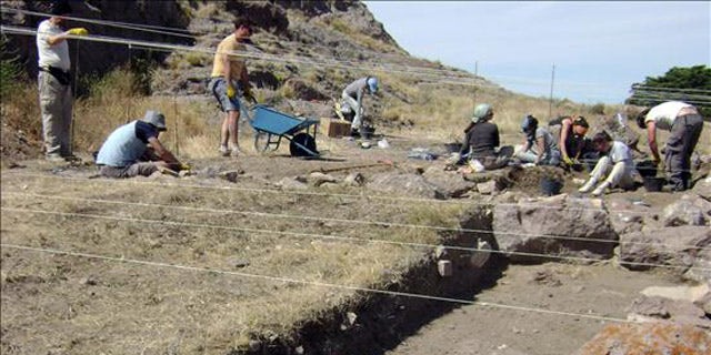 Argentine anthropologists search a lakeside beach, where they found human skeletal remains some 8,270 years old.