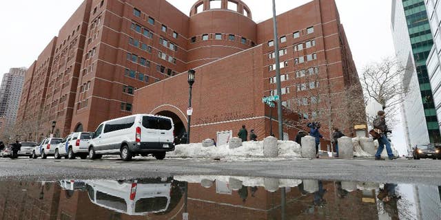 The John Joseph Moakley United States Courthouse is reflected in melted snow, Wednesday, March 4, 2015, in Boston.