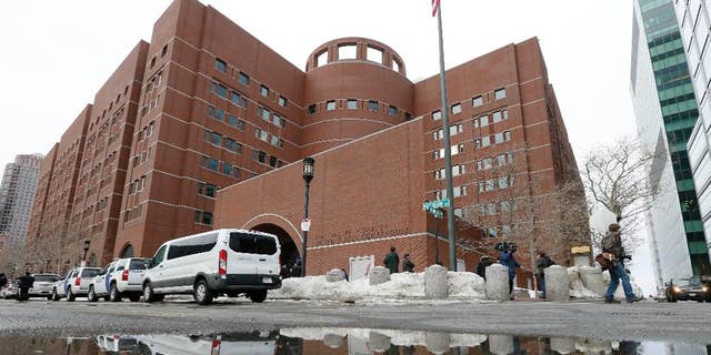 The John Joseph Moakley United States Courthouse is reflected in melted snow, Wednesday, March 4, 2015, in Boston.