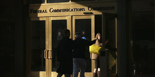 WASHINGTON, DC - DECEMBER 11: People enter the building of Federal Communications Commission December 11, 2014 in Washington, DC. The commission held its monthly meeting as activists held a rally outside to call for net neutrality. (Photo by Alex Wong/Getty Images)