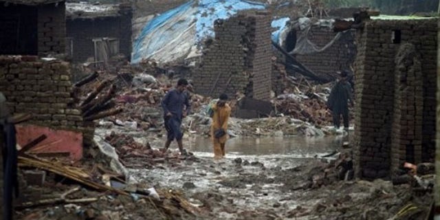 Aug. 8: Flood effected people walk past the rubble the collapsed houses in Azakhel near Nowshera, Pakistan. The country will need billions of dollars to recover from its worst floods in history, further straining a country already dependent on foreign aid to prop up its economy and back its war against Islamist militants, the U.N. said (AP).