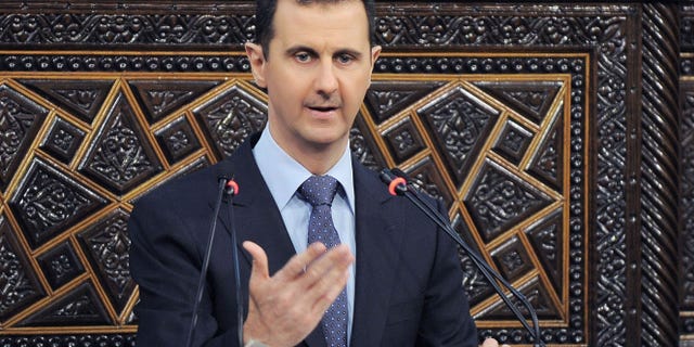 In this photo released by the Syrian official news agency SANA, shows Syrian President Bashar Assad, as he delivers a speech at the parliament in Damascus, Syria, Sunday, June 3, 2012. The president's first comments on the massacre expressed horror over the deaths of more than 100 people, nearly half of them children. U.N. investigators say there are strong suspicions that pro-government gunmen carried out the killings, but Assad denied that. (AP Photo/SANA)