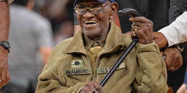 FILE - In this March 23, 2017, file photo, Richard Overton leaves the court after a special presentation honoring him as the oldest living American war veteran, during a timeout in an NBA basketball game between the Memphis Grizzlies and the San Antonio Spurs. Overton was honored by his hometown of Austin, Texas, on his 111th birthday on May 11, 2017. (AP Photo/Darren Abate, File)