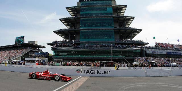 Scott Dixon, of New Zealand, crosses the start/finish line to start the 99th running of the Indianapolis 500 auto race at Indianapolis Motor Speedway in Indianapolis, Sunday, May 24, 2015. (AP Photo/Darron Cummings)