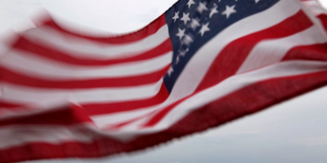 A U.S. flag flutters over top of the skyline of New York (R) and Jersey City (L), as seen from Bayonne, New Jersey, August 6, 2011. New York will mark the 10th anniversary of the attack on the World Trade Center with ceremonies on September 11. REUTERS/Gary Hershorn (UNITED STATES - Tags: CITYSCAPE DISASTER IMAGES OF THE DAY)