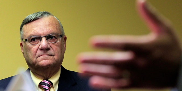 FILE - In this April 3, 2012 file photo, Maricopa County Sheriff Joe Arpaio listens to one of his attorneys during a news conference in Phoenix. Arpaio, who led the way for local police across the country to take up immigration enforcement, is reconsidering his crackdowns _ and other law enforcement officials who followed his lead are expected to eventually back away, too. (AP Photo/Ross D. Franklin, File)