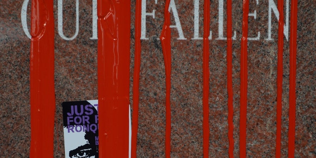 Stickers and red paint cover the fallen police memorial February 14, 2015 at the Denver Police Administration Building.