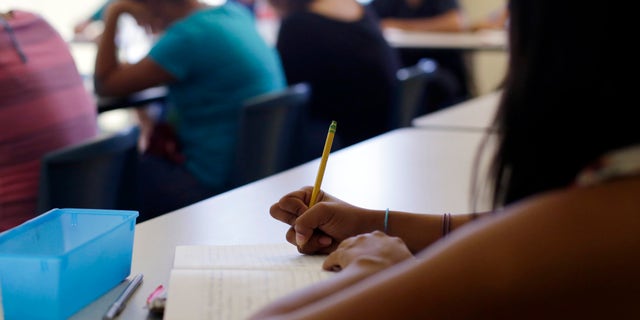 In this Wednesday, Sept. 10, 2014 photo, math is taught to high school students during a class at the Karnes County Residential Center, a temporary home for immigrant women and children detained at the border, in Karnes City, Texas. (AP Photo/Eric Gay)