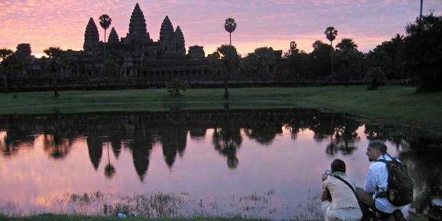 FILE - In this July 14, 2014 file photo, tourists look at the view of the Angkor Wat temples at sunrise, outside Siem Reap, Cambodia.