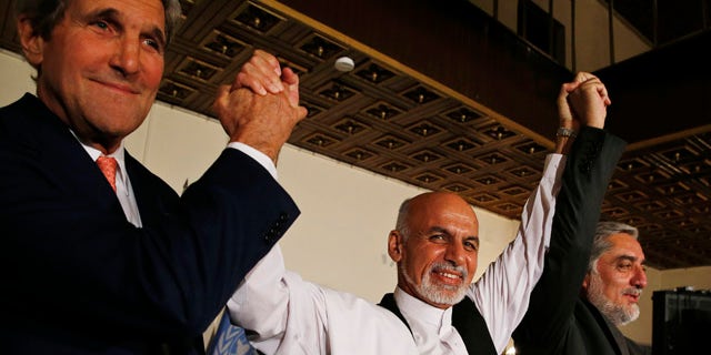 July 12, 2014: U.S. Secretary of State John Kerry, left, and Afghanistan's presidential candidates Ashraf Ghani, center, and Abdulah Abdullah hold their arms in the air together after announcing a deal for the auditing of all Afghan election votes at the United Nations Compound in Kabul. (AP Photo/Jim Bourg, Pool)