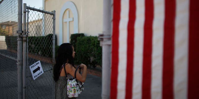LOS ANGELES, CA - NOVEMBER 6: A woman enters a polling place in the heavily Latino East L.A. area during the U.S. presidential election on November 6, 2012 in Los Angeles, California. The election will decide whether Democrat Barack Obama serves a second term as president of the United States or is replaced by Republican rival, former Massachusetts Gov. Mitt Romney. (Photo by David McNew/Getty Images)