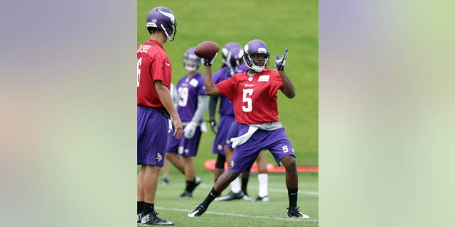 Minnesota Vikings quarterback Matt Cassel, left, watches as rookie quarterback Teddy Bridgewater throws during NFL football minicamp Wednesday, June 18, 2014, in Eden Prairie, Minn. (AP Photo/Jim Mone)