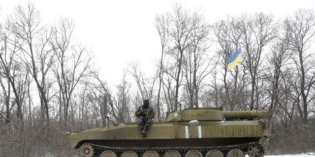 Feb. 16, 2015: An Ukrainian soldier rests on his vehicle near the road between the towns of Debaltseve and Artemivsk. (AP Photo/Petr David Josek)