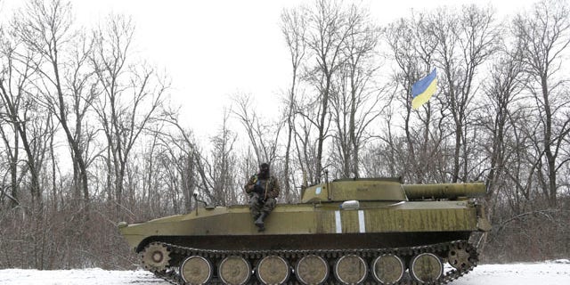 Feb. 16, 2015: An Ukrainian soldier rests on his vehicle near the road between the towns of Debaltseve and Artemivsk. (AP Photo/Petr David Josek)