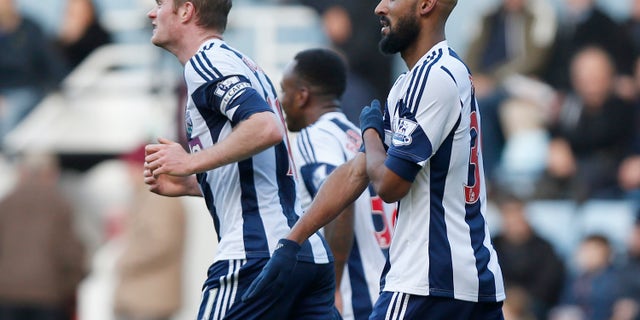 El jugador de West Bromwich Albion, Nicolas Anelka, derecha, gesticula al festejar un gol contra West Ham en la liga Premier el 28 de diciembre de 2013. (AP Photo/Sang Tan, File)