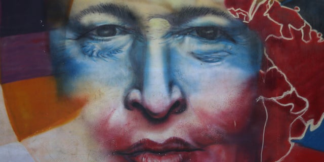 CARACAS, VENEZUELA - MARCH 04: A mural honors former Venezuelan president Hugo Chavez near the military barracks where Chavez is entombed on March 4, 2014 in Caracas, Venezuela. Workers made last minute preparations for Wednesday's ceremony marking the first anniversary of Chavez' death on March 5, 2013. The anniversary has been marred by three weeks protests against the government of Chavez' chosen successor Nicolas Maduro. (Photo by John Moore/Getty Images)