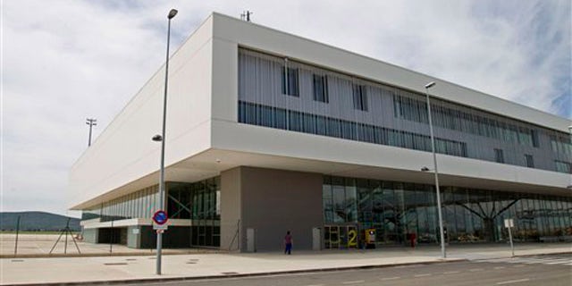 In this Wednesday, May 11, 2011, a man walks alongside the new Central airport terminal in Ciudad Real, Spain. The glittering buildings rise up from Spain's arid central plain. Draw closer and there's something eerie about Ciudad Real's Central Airport. There's hardly a plane in sight. Nobody's around. Cars can only be heard faintly in the distance. This is one of Spain's "ghost airports" huge projects often funded by taxpayer money that helped drive Spain's economic boom and now symbolize the wasteful spending that helped trigger its catastrophic bust.