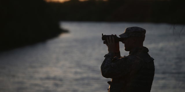 HAVANA, TX - SEPTEMBER 11: A Texas National Guard soldier scans the Mexican side of the U.S.-Mexico border on September 11, 2014 in Havana, Texas. The troops, deployed along the Rio Grande, are part of a 1,000 strong force called up by Texas Governor Rick Perry to guard the border. The soldiers were sent to help state and federal law enforcement stem a surge of illegal immigrants, many of them families and unaccompanied minors. (Photo by John Moore/Getty Images)
