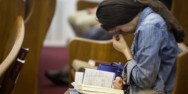 April 6, 2014: Kathy Abad, a military wife, prays for the victims and families affected by the Fort Hood shooting during a memorial service at the Tabernacle Baptist Church.