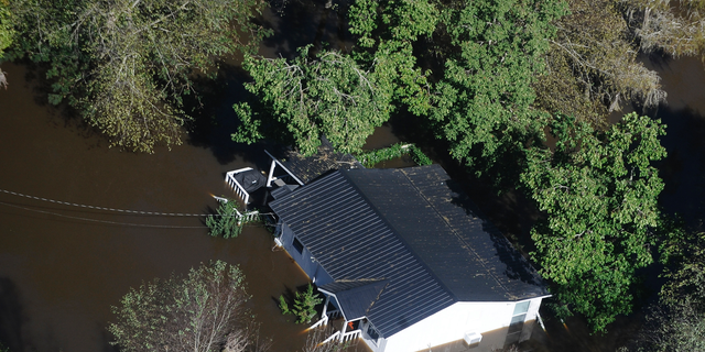 FILE-In this Monday, Oct. 10, 2016 file photo, a home sits in flood waters in Nichols, S.C. The residents of a tiny town in South Carolina who rebuilt after an inland flood from a hurricane destroyed 90 percent of the homes two years ago are uneasy as forecasters warn inland flooding from Hurricane Florence's rain could be one of the most dangerous and devastating parts of the storm. (AP Photo/Rainier Ehrhardt, File)
