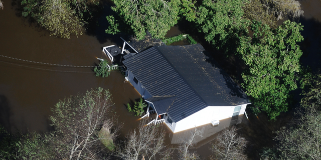 FILE-In this Monday, Oct. 10, 2016 file photo, a home sits in flood waters in Nichols, S.C. The residents of a tiny town in South Carolina who rebuilt after an inland flood from a hurricane destroyed 90 percent of the homes two years ago are uneasy as forecasters warn inland flooding from Hurricane Florence's rain could be one of the most dangerous and devastating parts of the storm. (AP Photo/Rainier Ehrhardt, File)