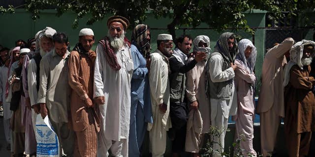 Afghan men wait in line to receive food donation during the holy month of Ramadan in Kabul, Afghanistan, Thursday, June 25, 2015. Muslims throughout the world are marking the month of Ramadan, the holiest month in the Islamic calendar during which devotees fast from dawn till dusk. (AP Photo/Massoud Hossaini)