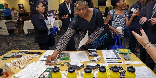 In this photo taken Friday, Feb. 6, 2015, U.S. Army Veteran Fay Belton picks up job information at the annual Veterans Career and Resource Fair in Miami. The U.S. Labor Department reports on the number of people who applied for unemployment benefits for the week ending Feb. 14 on Thursday, Feb. 19, 2015. (AP Photo/Alan Diaz)