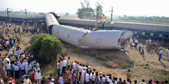 Indian people gather at the site of a train accident near Nashik, 165 kilometers (100 miles) north of Mumbai, India, Friday, Nov. 15, 2013. Police say the passenger train derailed in western India, killing at least two people and injuring another 25. The cause of the accident was not immediately known. (AP Photo)