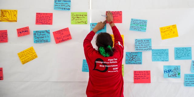 WASHINGTON, DC - APRIL 7:
Antonia Surco, of Silver Spring, Maryland, hangs hand-written messages about fasting for immigration reform on the wall of a tent on the National Mall, during the 'Women's Fast For Families' event, April 7, 2014 in Washington, DC. According to organizers, around 100 women signed up to fast for 48 hours on the National Mall to call for 'fair immigration reform and an end to deportations.' (Drew Angerer/Getty Images)